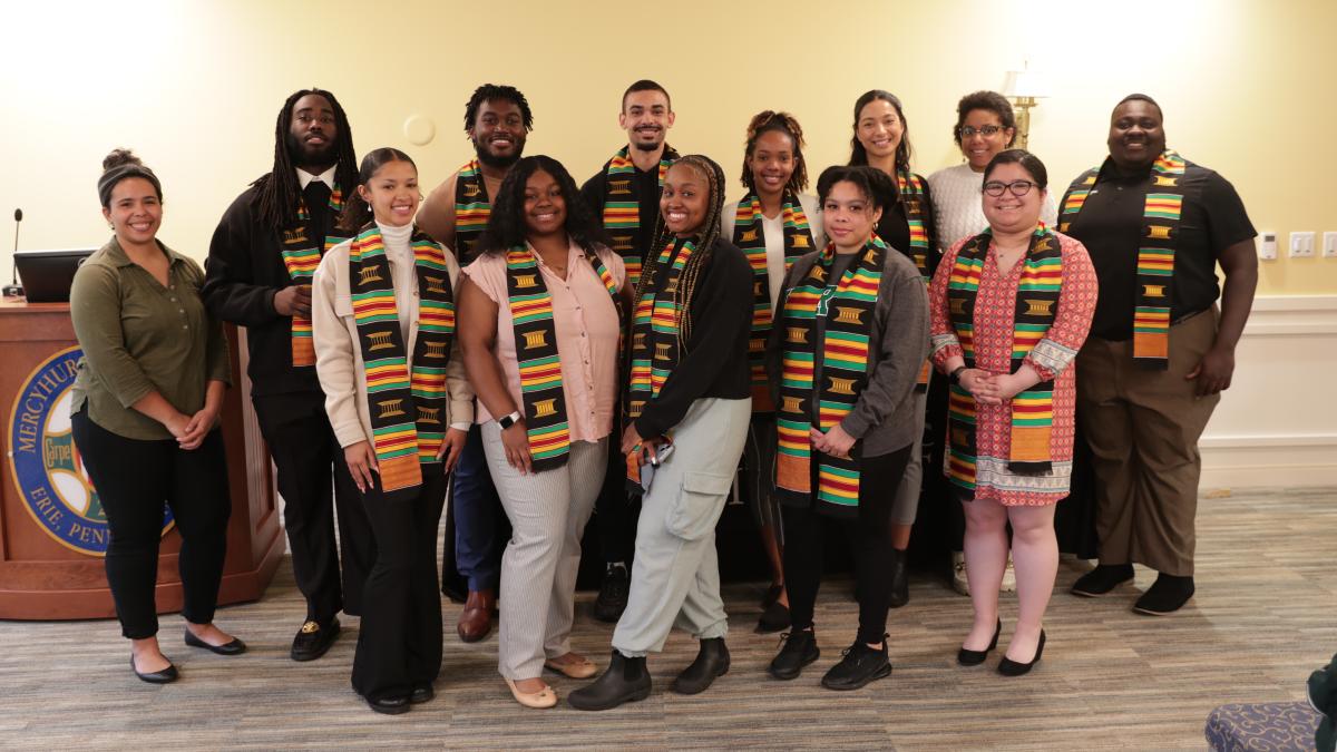 a group of Ĳʿ students wear traditional kente stoles